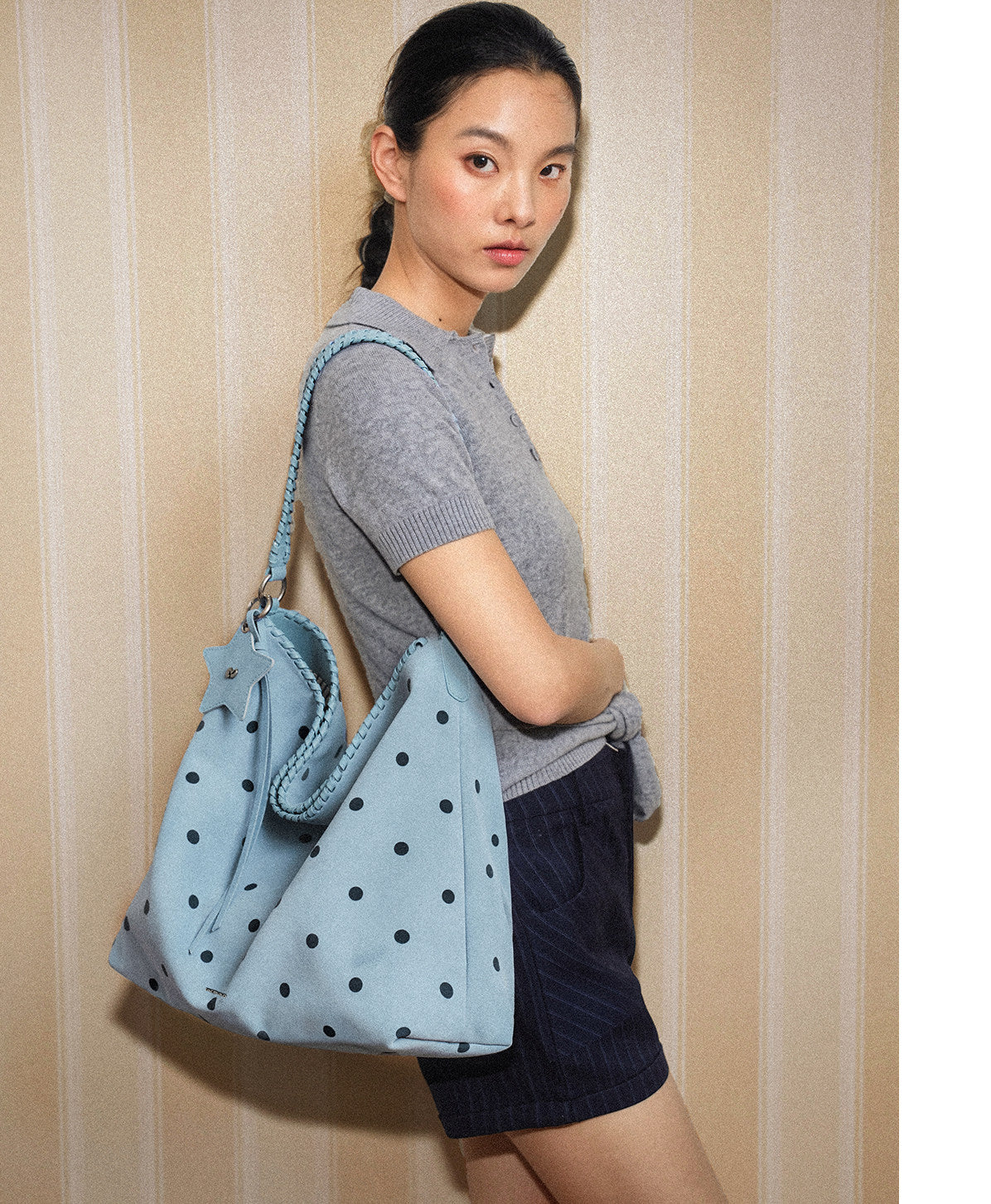 Blue polka dot McMiko hobo bag worn over the shoulder by a model